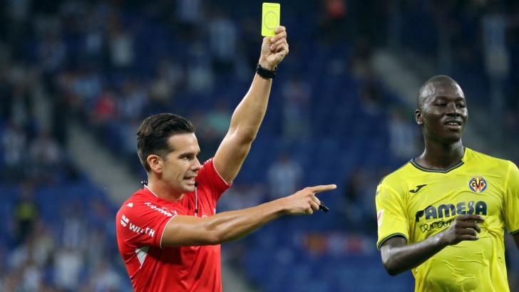 Spanish referee Alejandro Quintero Gonzalez shows a yellow card